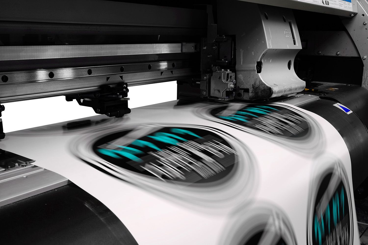 Großformatdrucker druckt mehrere runde Aufkleber mit Text und blau-grünen Akzenten
