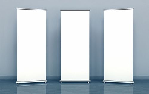 Drei weiße, leere Roll-up-Banner nebeneinander vor grauer Wand